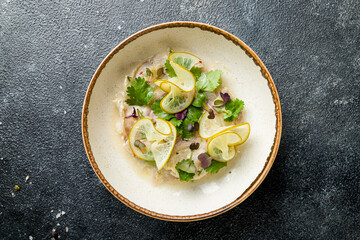 ceviche from dorado on plate on dark stone table top view