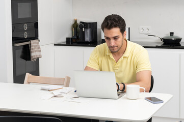 Close up of unhappy man sitting at the table, stressed and confused by calculate expense from invoice or bills, have no money to pay mortgage or loan. High prices and spending money concept