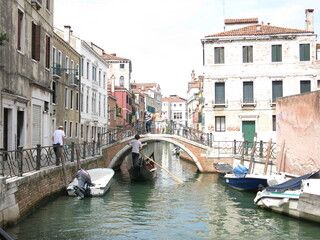 Fototapeta na wymiar Gondolier mit Brücke in Venedig