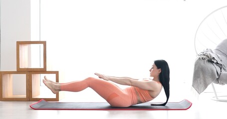 Slim sporty girl doing v-ups abs workout at home.