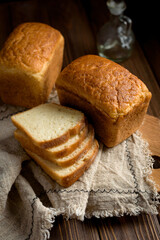 
loaves and sliced ​​pieces of cornbread on a wooden board, dark background