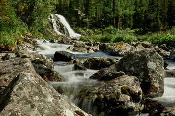 Fototapeta na wymiar Waterfall of Lake Poperechnoe on the Multa River in the Katunsky Reserve of Altai