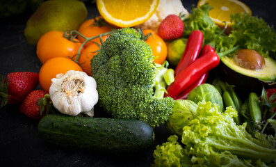 Different vegetables and fruits on a dark background