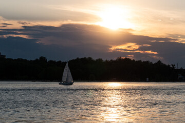 Yacht against the backdrop of contrasting sunset rays