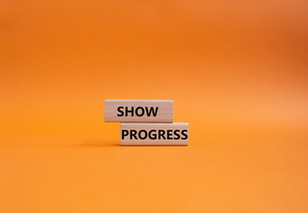 Progress symbol. Wooden blocks with words Show progress. Beautiful orange background. Business and Show progress concept. Copy space.