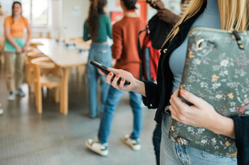 Crop student using smartphone before lesson