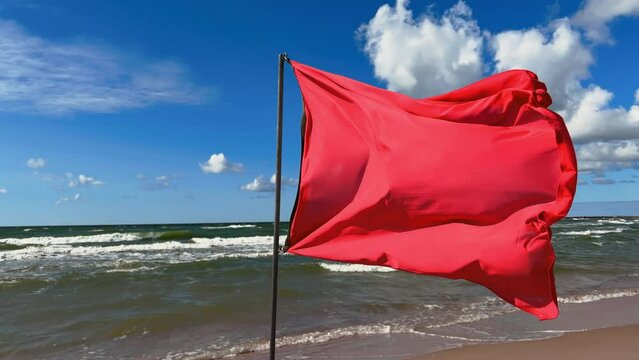 Danger: Red flag is warning about the prohibition of swimming on the beach