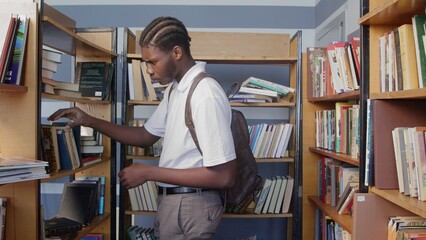 4K. An African-American man reads a book in the library