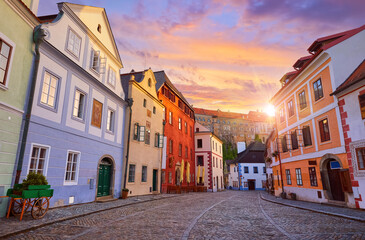 Cesky Krumlov, Czech Republic. Ancient street with old houses and paving stones road. Evening sunset with sunlight.