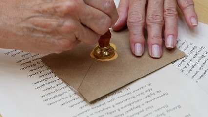 4K. Sealing the invitation with wax using a candle
