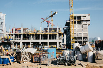 construction equipment and construction debris on the site in front of the houses