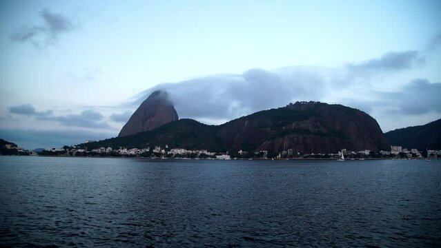 Lockdown Time Lapse Shot Of Sugarloaf Mountain By Rippled Ocean Under Cloudy Sky - Rio de Janeiro, Brazil