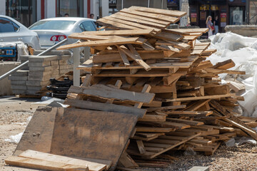 Dump of wooden boards, waste, bags and garbage on the main street of the city, road repair