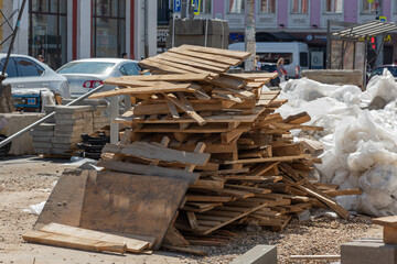 Dump of wooden boards, waste, bags and garbage on the main street of the city, road repair