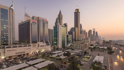 Fototapeta na wymiar Downtown Dubai towers day to night transition timelapse. Aerial view of Sheikh Zayed road with skyscrapers after sunset. Traffic on the road and parking