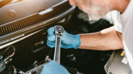 Auto mechanic working in garage. Repair service.