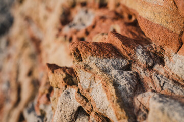 Uneven surface of rough rocky cliff on sunny day