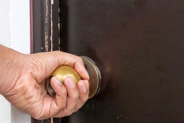hand turning a doorknob to open door