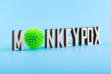 Wooden letters text MONKEYPOX on a blue background. Monkeypox virus concept.