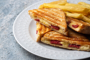 Turkish toast, mixed toast with cheddar cheese, sausage and ham, with fried potatoes (Turkish name; Karisik tost)