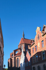 Fototapeta na wymiar Historic buildings and back side of St. Nicholas Church in Wismar, Germany with blue sky.