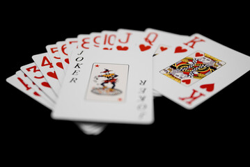 A set of play cards with a joker on top