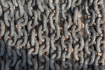 Close-up of metal cast-iron links of a large chain, laid out in a row, old metal, rust