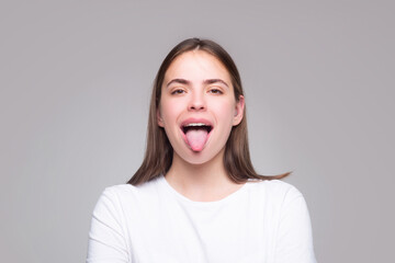Beautiful modern model shows tongue. Model with sticking tongue out. Girl showing tongue. Emotional...