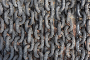 Close-up of metal cast-iron links of a large chain, laid out in a row, old metal, rust
