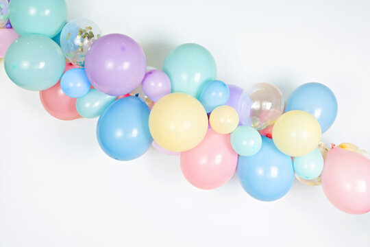 A close up image of a soft pastel balloon garland against a white background