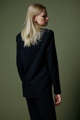 A beautiful attractive model poses with her back to the camera. Concept photo for clothing brands. Cool offer for fashionable suits