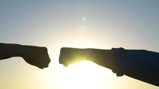 Male fists against the sky, trust, harmony, friendship. Teamwork concept. Fist to fist - a sign, expresses consent, a gesture of respect. Lifestyle business team clenching their fists close up.