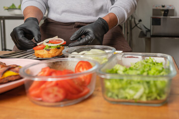 Cook preparing a classic hamburger in a restaurant kitchen