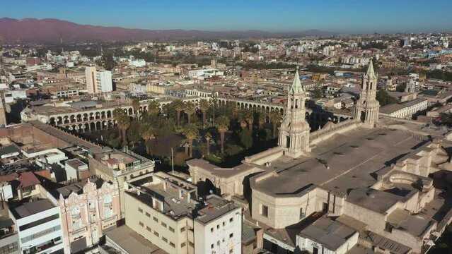 Aerial drone view of Arequipa main square and cathedral church, with the Misti volcano at sunset. Arequipa, Peru.