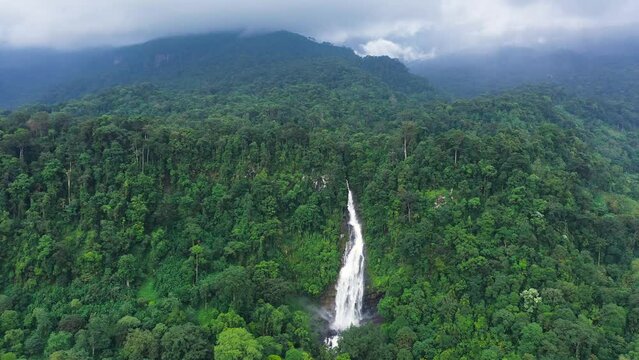 Aerial drone of waterfall in a mountain canyon surrounded by jungle. Mapalana Falls. Sri Lanka.
