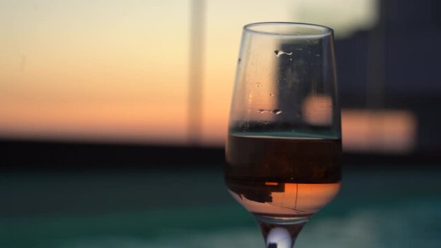 A glass of champagne with a beautiful sunset view behind