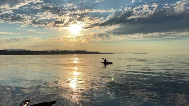 adult woman on a sports holiday she paddles while sitting on a kayak is kayaking for the first time leisure for adults travel agency beautiful weather pacific ocean Parksville beach Surfside RV resort