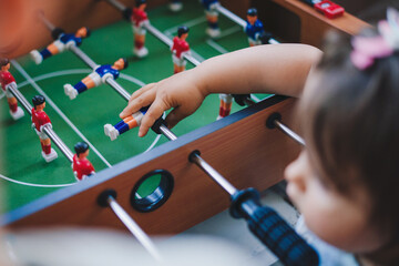 Little boy and girl enjoying playing football table toy. Happy family, childhood. Children play table games.