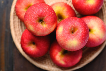Red apple fruit in basket on wooden background, Table top view