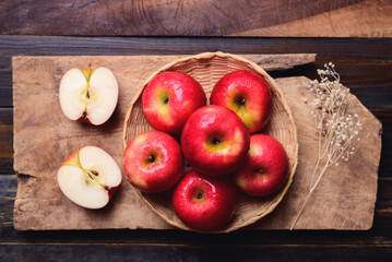 Red apple fruit in basket on wooden background, Table top view