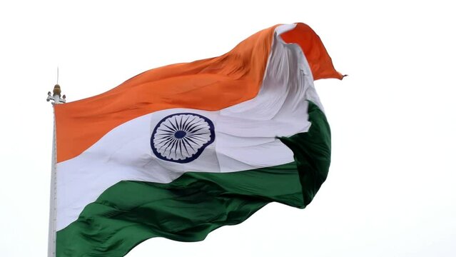 India flag flying high at Connaught Place with pride in blue sky, India flag fluttering, Indian Flag on Independence Day and Republic Day of India, tilt up shot, Waving Indian flag, Har Ghar Tiranga