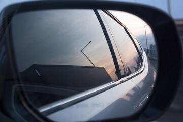 
A side view of the car reflected in the car's side mirror