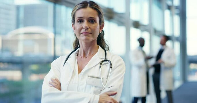 Serious, dedicated and confident female doctor standing arms crossed in a hospital, medical clinic or healthcare ward. Portrait of a woman wearing a labcoat and stethoscope looking ready to help