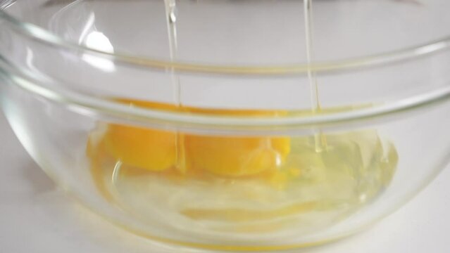 Crack an egg straight into a glass bowl at home kitchen to making cake.