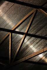 Canopy made of polycarbonate with drops of morning dew in sunny weather. Black metal construction. Bottom view.