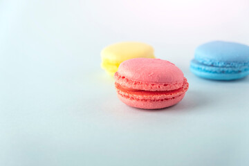 Colorful french macarons cookies (macaroons) on blue background. Dessert, vegetarian sweets close up