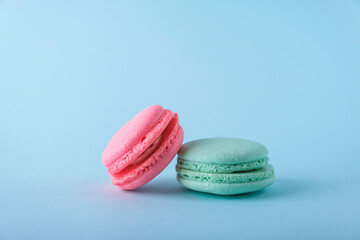 Colorful french macarons cookies (macaroons) on blue background. Dessert, vegetarian sweets close up