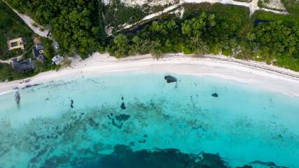 Aerial view of beach with white sand and shallow clear blue water in Jamaica 