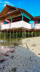 A simple plank house made of wood and poles using tree trunks stands firmly on the edge of the beach.  It is located at Ratu Beach, Boalemo Regency, Gorontalo Province.  Outdoor photo taken on August 