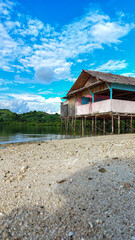 Obraz premium A simple plank house made of wood and poles using tree trunks stands firmly on the edge of the beach. It is located at Ratu Beach, Boalemo Regency, Gorontalo Province. Outdoor photo taken on August 